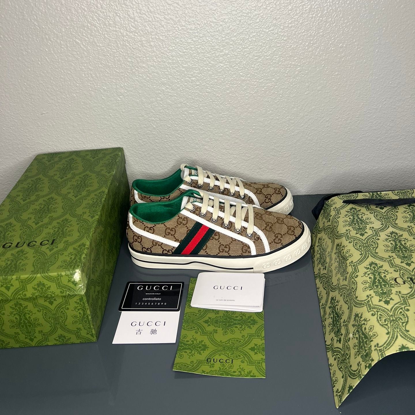 Gucci sneakers with packaging on a gray surface