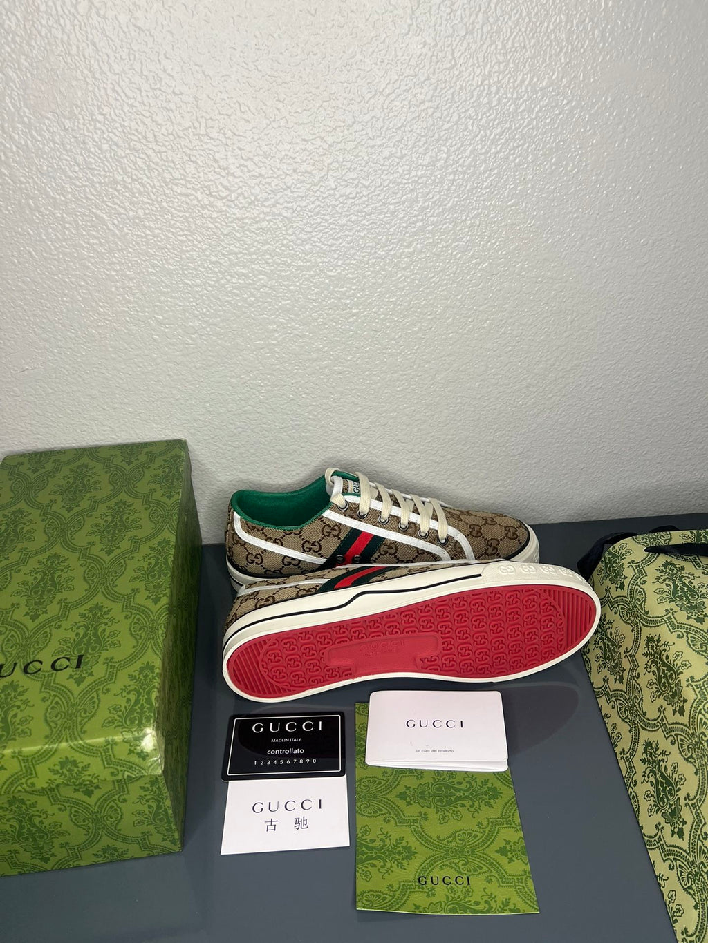 Gucci sneaker with packaging on a gray surface