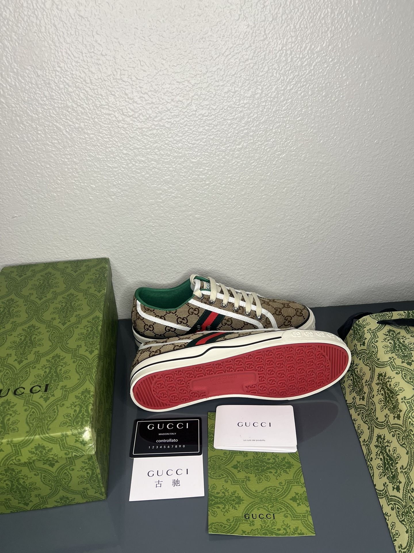 Gucci sneaker with packaging on a gray surface