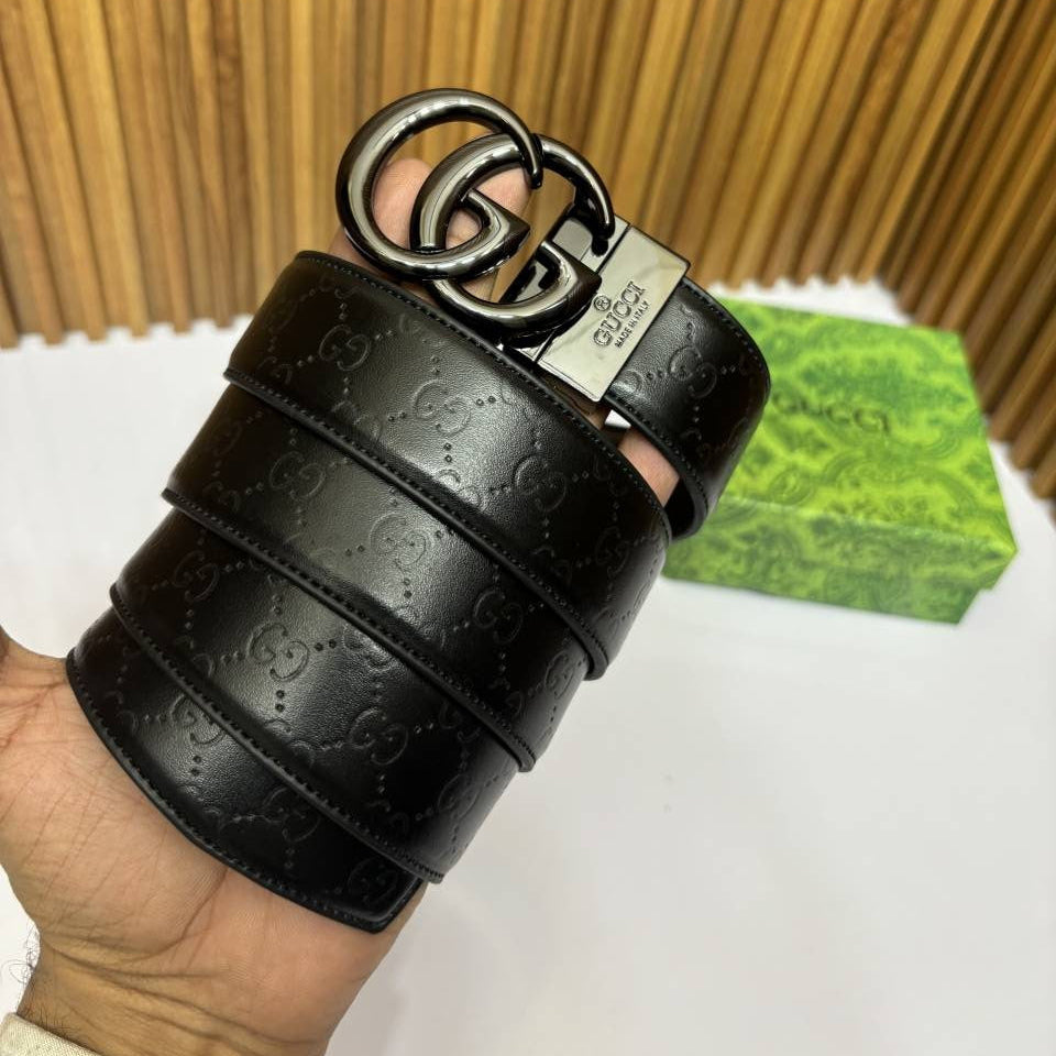 Black Gucci belt with interlocking G logo on a wooden surface