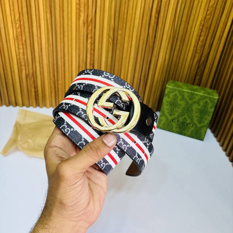 Hand holding a belt with a prominent logo against a wooden background