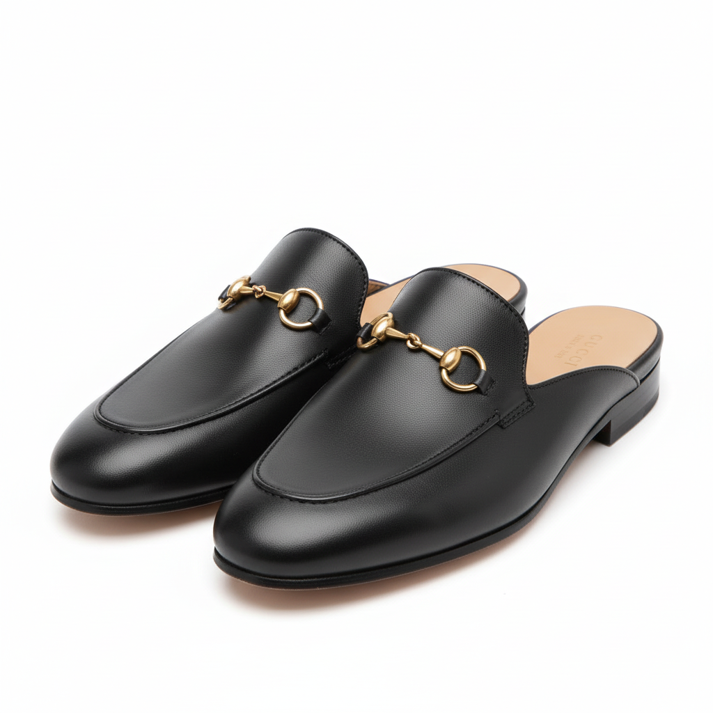 Black  Gucci mulesslip-on shoes with gold accents on a light gray background