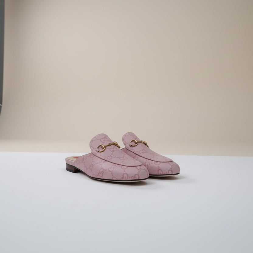 Pink shoes with heart designs and gold accents on a light gray background