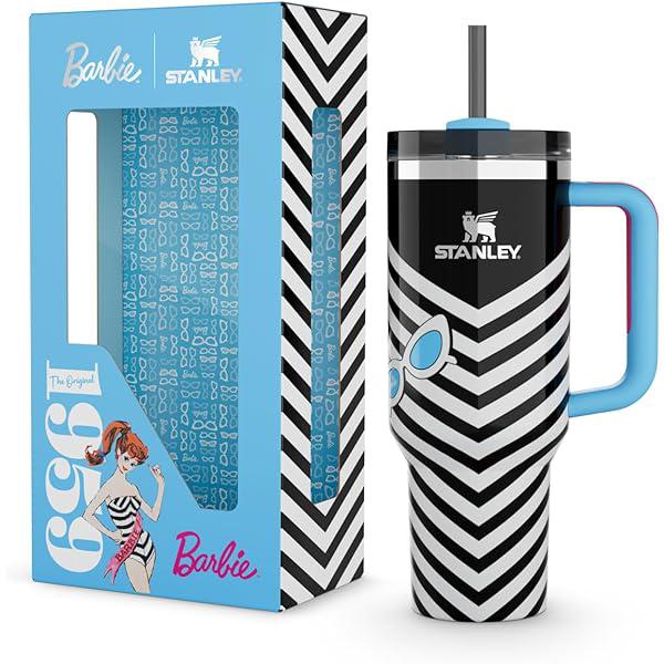 Stanley mug with black and white chevron pattern and blue handle, next to Barbie-themed packaging.