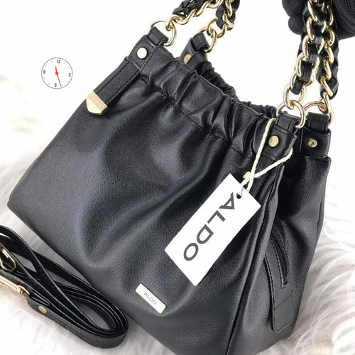 Black handbag with gold chain strap and Aldo label on a white background