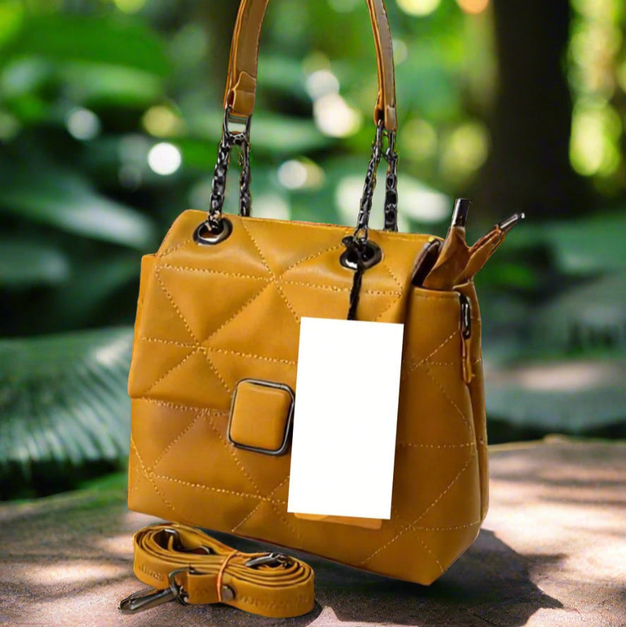 Yellow leather handbag with a strap on a wooden surface, bookshelf in the background