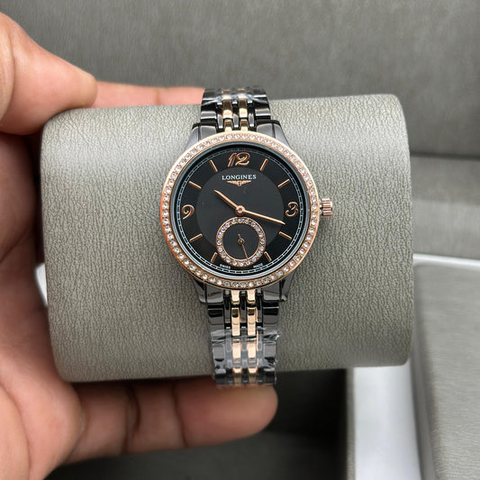 Luxury watch with black dial and rose gold accents held by a hand on a gray surface.