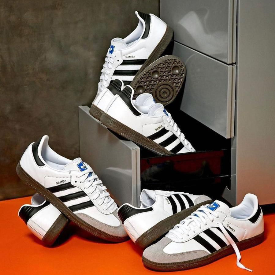 White sneakers with black stripes on a reflective surface