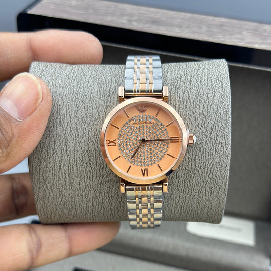 Gold watch on a gray cushion held by a hand with a gray box in the background