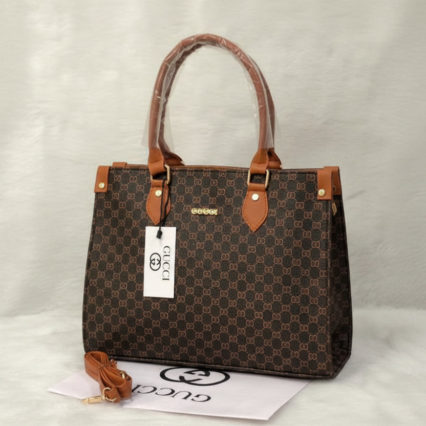 Tan Gucci handbag with a matching strap on a white surface.