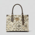 Floral patterned handbag with a brand logo on a blurred background