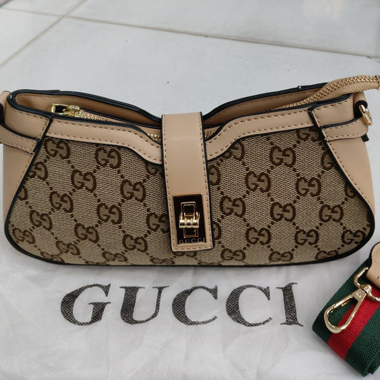 Beige Gucci handbag with monogram pattern on a white surface