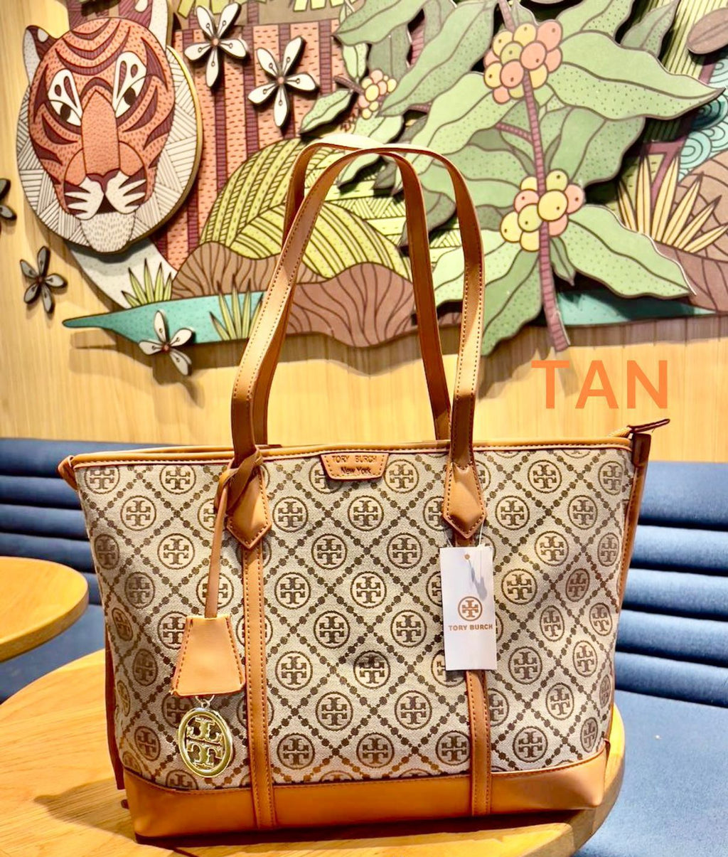 Designer handbag with brand tag on a wooden table against a colorful wall.