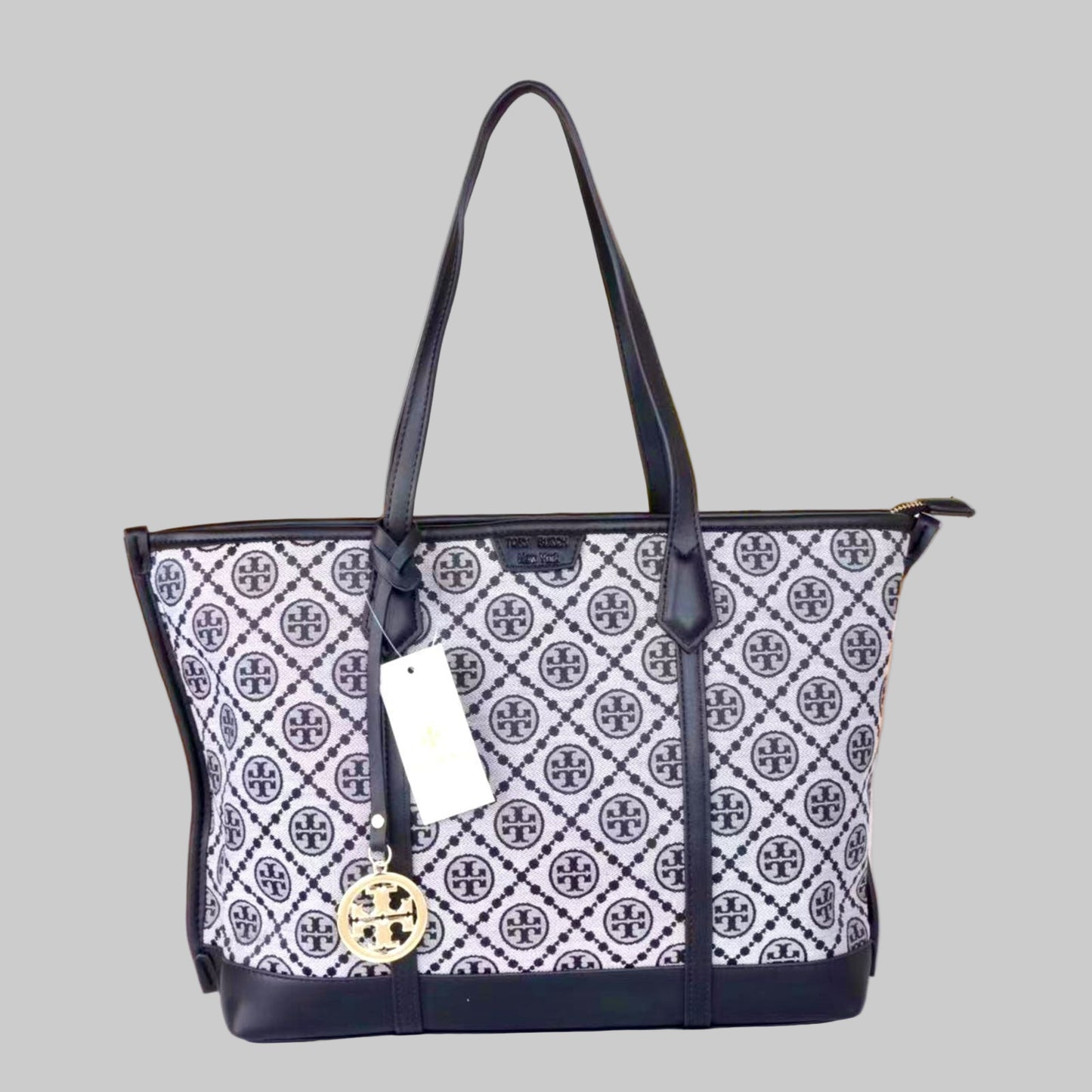 Designer handbag with patterned design and visible brand logo on a blurred background