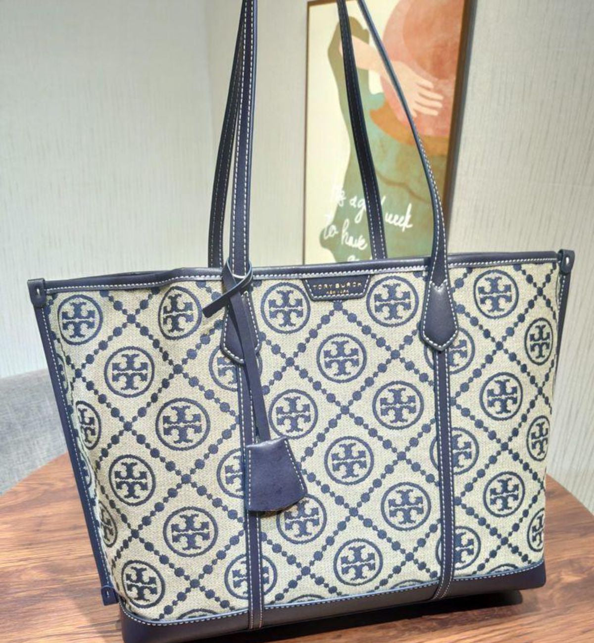 Designer handbag with brand logo on a wooden surface