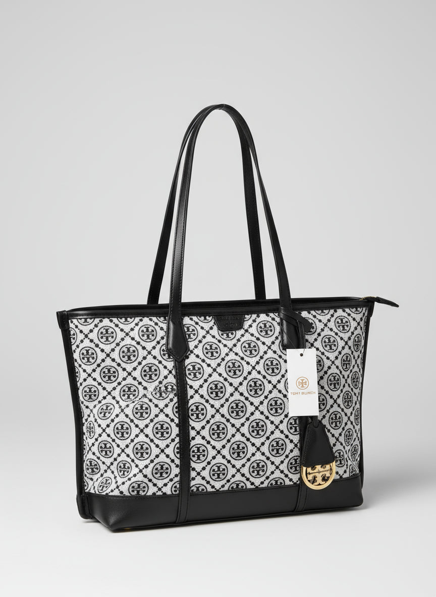 Patterned handbag with black zip closure next to a potted plant