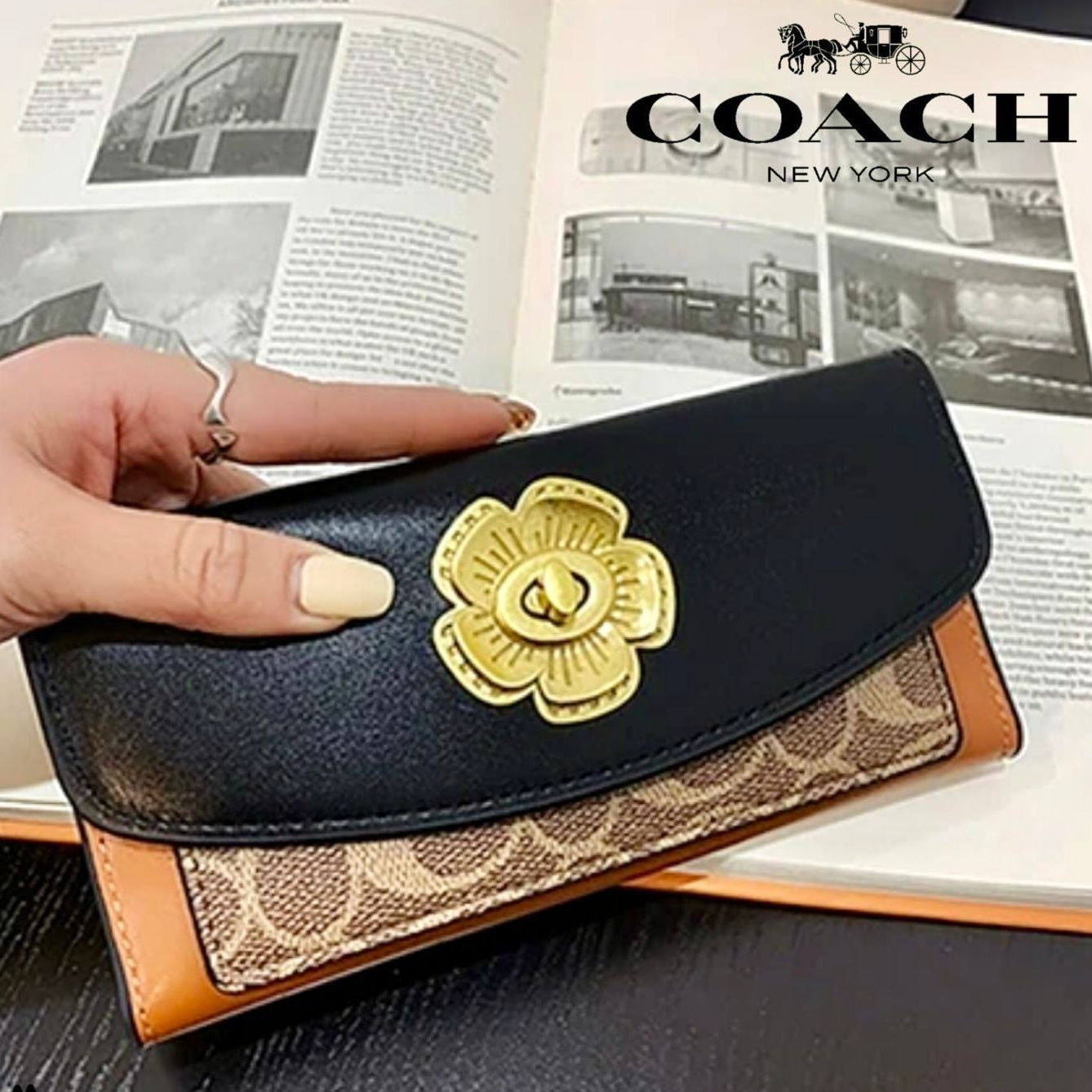 Coach wallet with floral emblem held over an open magazine featuring Coach branding.
