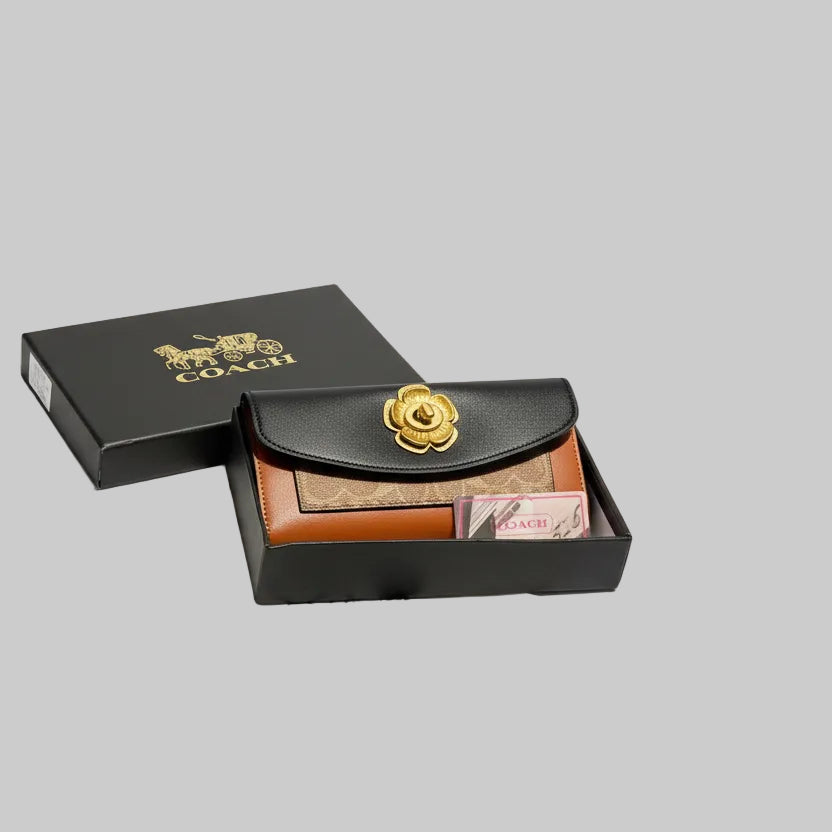 Coach wallet with gold emblem on a wooden surface with Coach branding.