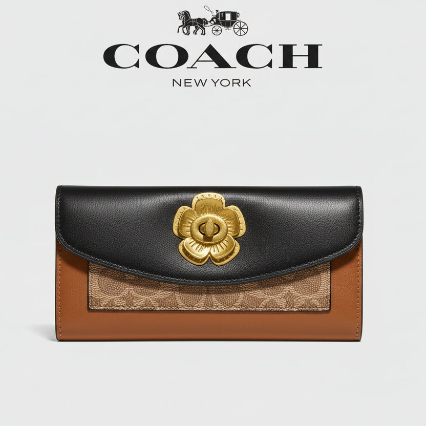 Coach wallet with gold flower emblem on a wooden surface