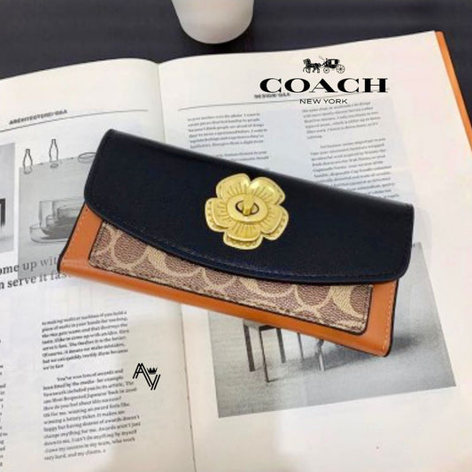 Coach wallet with gold flower emblem on an open magazine