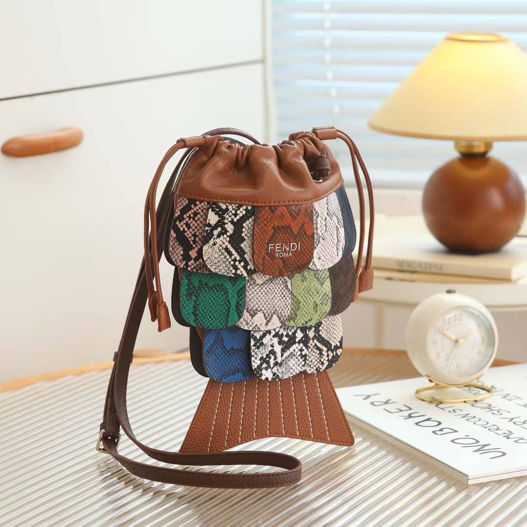 Brown Fendi Fish Sling Bag  Fendi patchwork handbag on a table with a lamp and books in the background