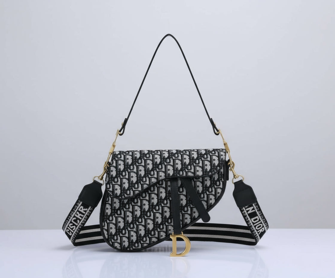 Christian Dior handbag with monogram pattern and branded strap on a white background