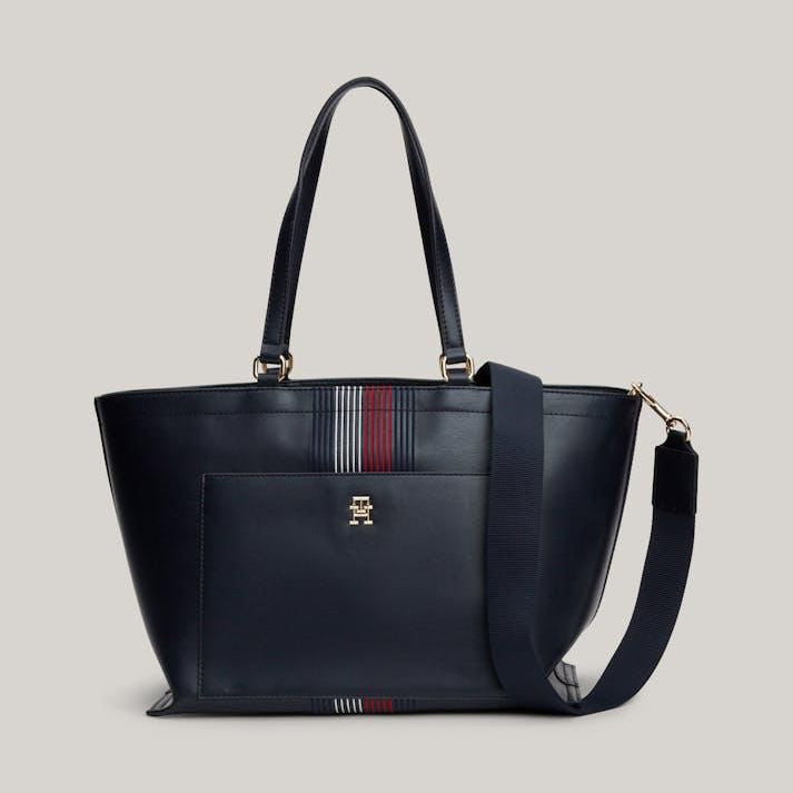Navy blue handbag with a strap on a light gray background