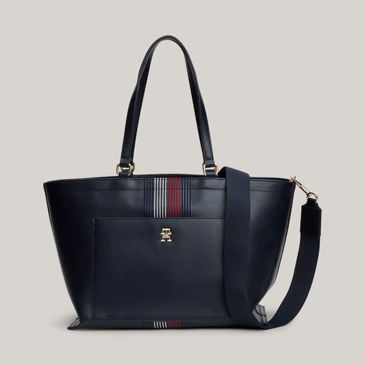 Navy blue handbag with a strap on a light gray background