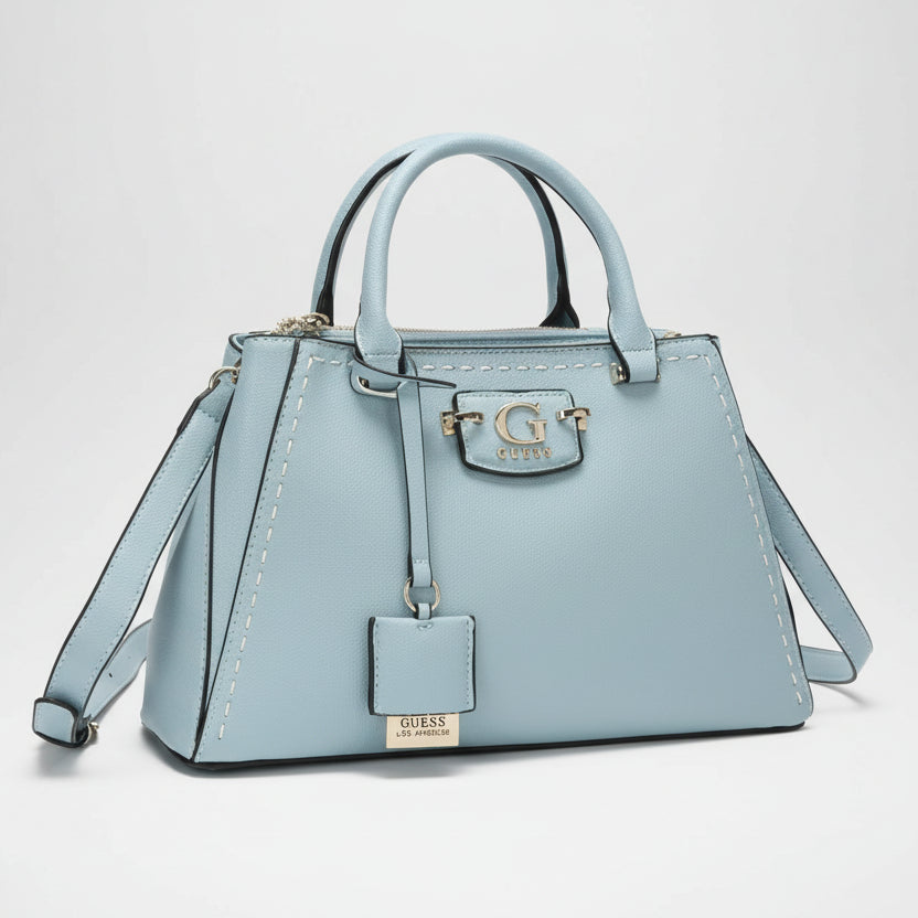 sky blue Guess Premium Quality Handbag with Full Brand Detailing and Dust Cover 
Light blue handbag with gold accents on a white background