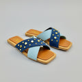 Zara sandals with blue straps and gold studs on a wooden surface with Zara packaging.