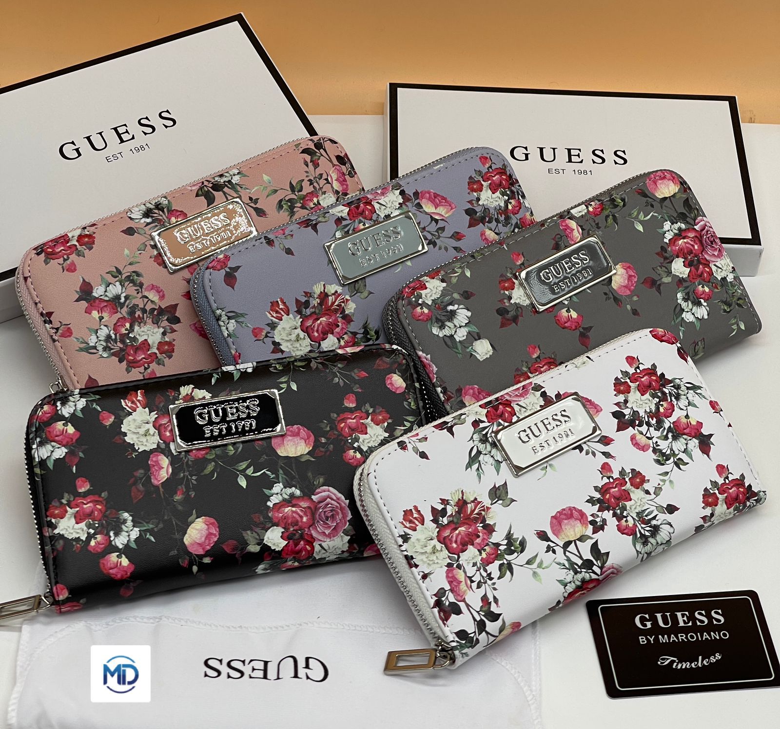 Set of floral-patterned wallets with Guess branding on a white surface.