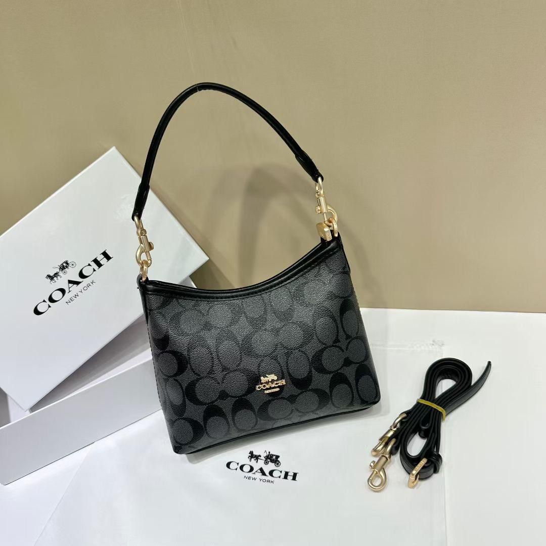 Black Coach Tabby Handbag Coach handbag with matching strap on a beige and white background