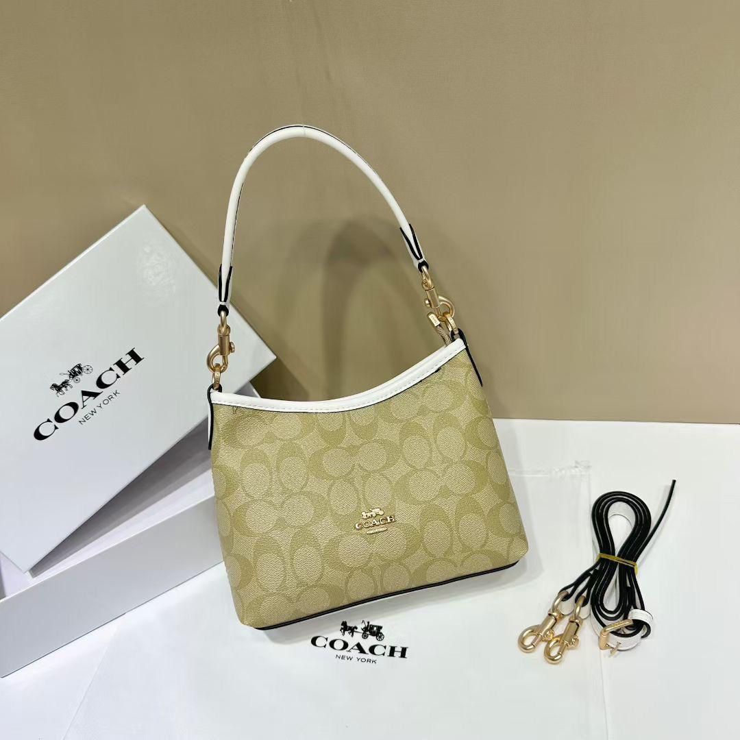 White Coach Tabby Handbag Coach handbag with matching strap and branded box on a beige background