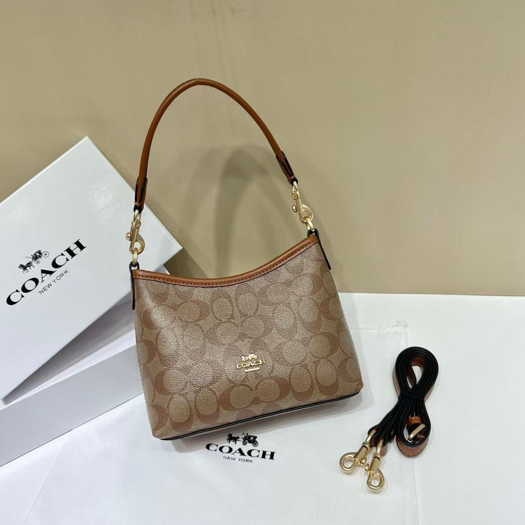 Brown Coach Tabby Handbag Coach handbag with matching strap on a white surface with Coach branding.
