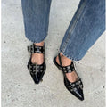 Black CHLOÉ Western Look Footwear  pointed-toe shoes with studded details worn with blue jeans on a concrete surface.