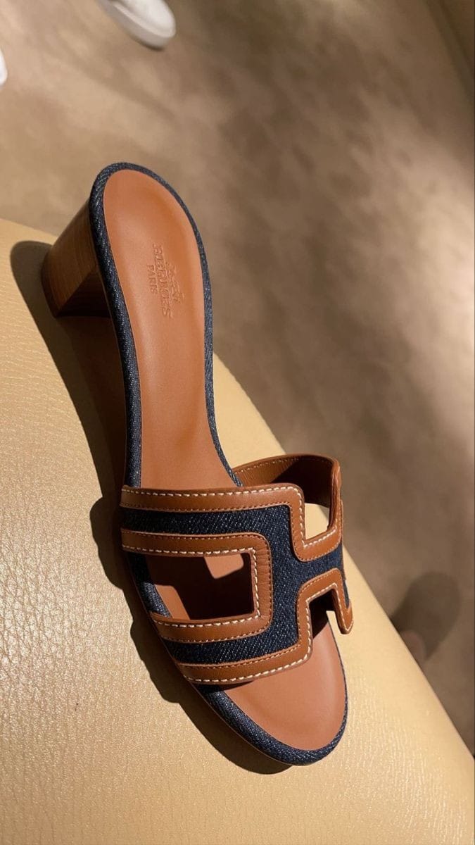 Navy blue HERMES Heel sandal with brown strap on a beige surface