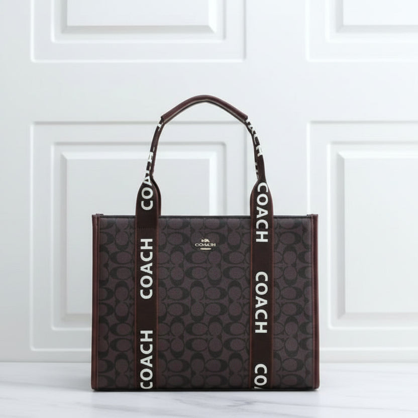 Tan Coach Large Smith Tote Bag Coach tote bag with logo straps on a white surface