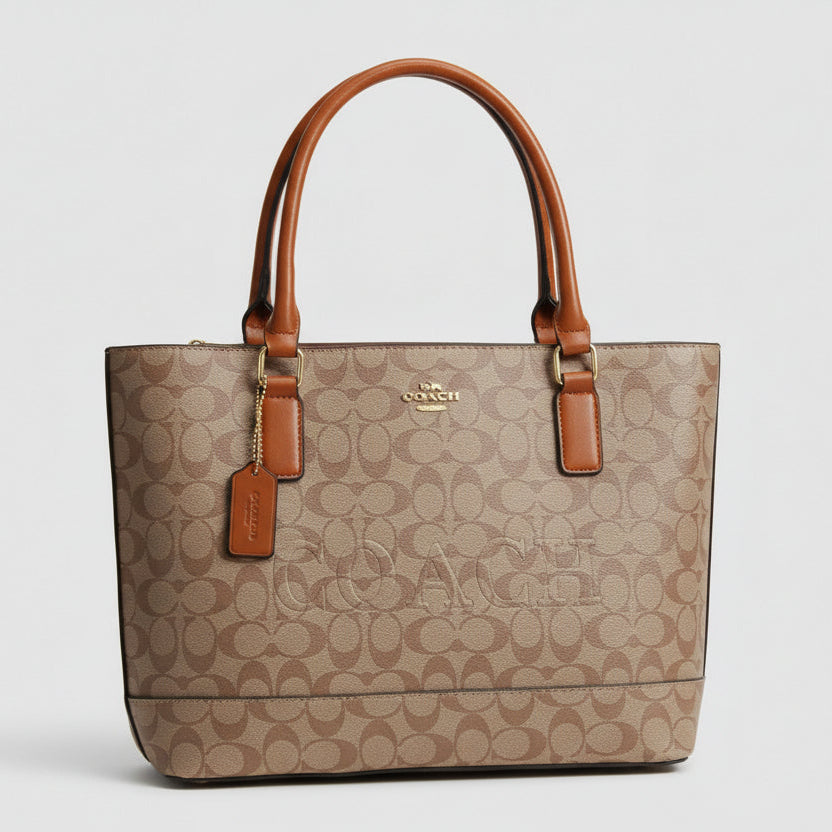 Brown Coach Gallery Tote Bag  handbag with brown handles and accents on a white surface with decorative elements.