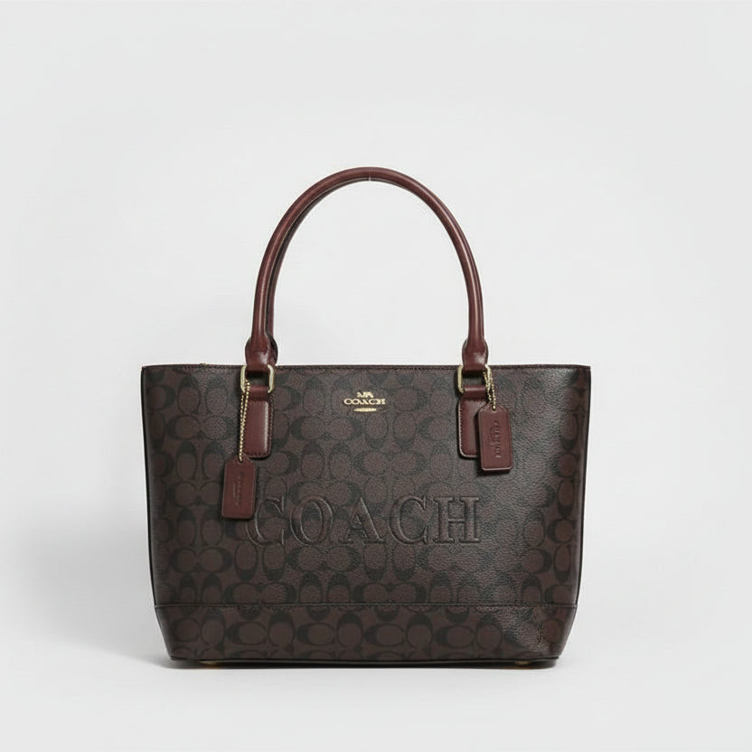 Black Coach Gallery Tote Bag  Coach handbag with a matching pouch on a marble surface with flowers in the background