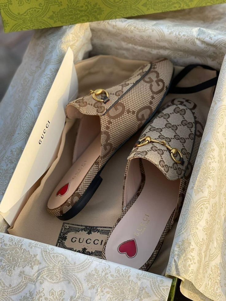 Brown  Gucci  mules shoes with a patterned box in the background