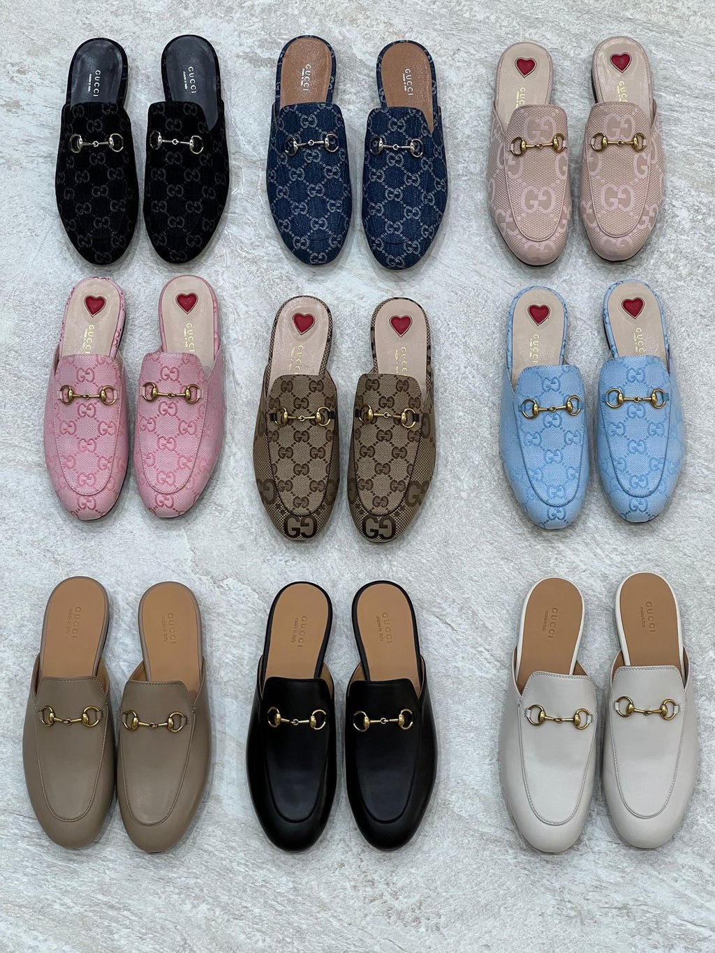 Collection of Gucci loafers in various colors on a textured surface