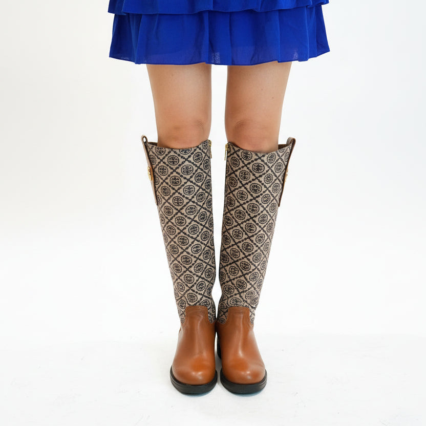 Person wearing a blue dress, patterned leggings, and brown shoes in an indoor setting.