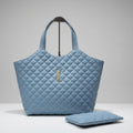 sky blue YSL Big Size Tote Bag with Small Wallet quilted handbag with a logo on a wooden surface against a textured wall.
