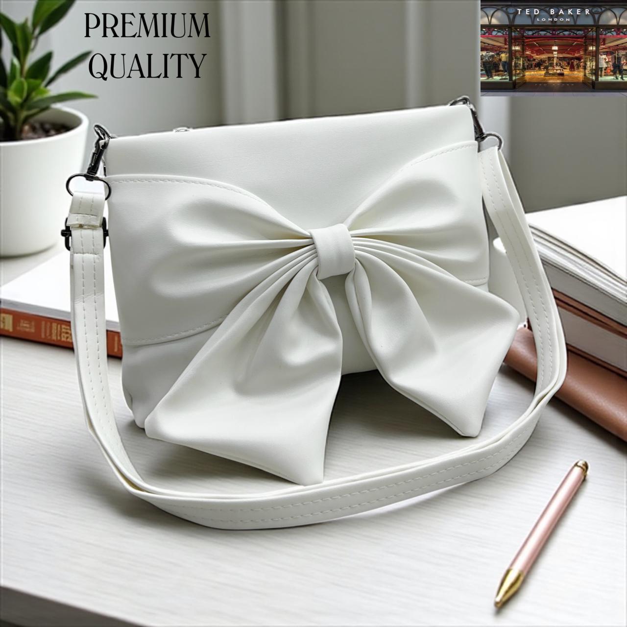 White TED BAKER London Premium Sling Bag handbag with a large bow on a light surface, with 'PREMIUM QUALITY' text above.