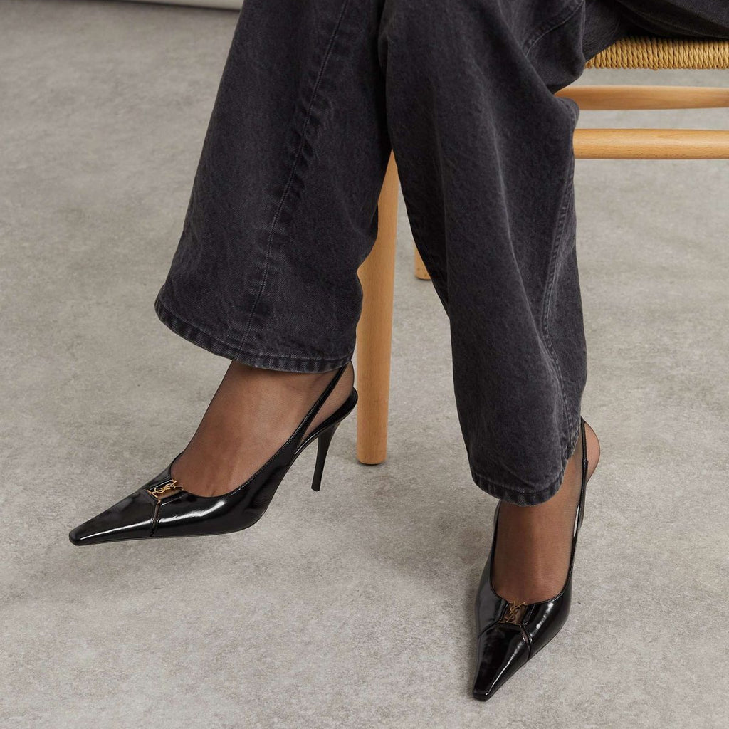 YSL Babylone Women’s Pumps Person wearing black high-heeled shoes and black jeans sitting on a chair.