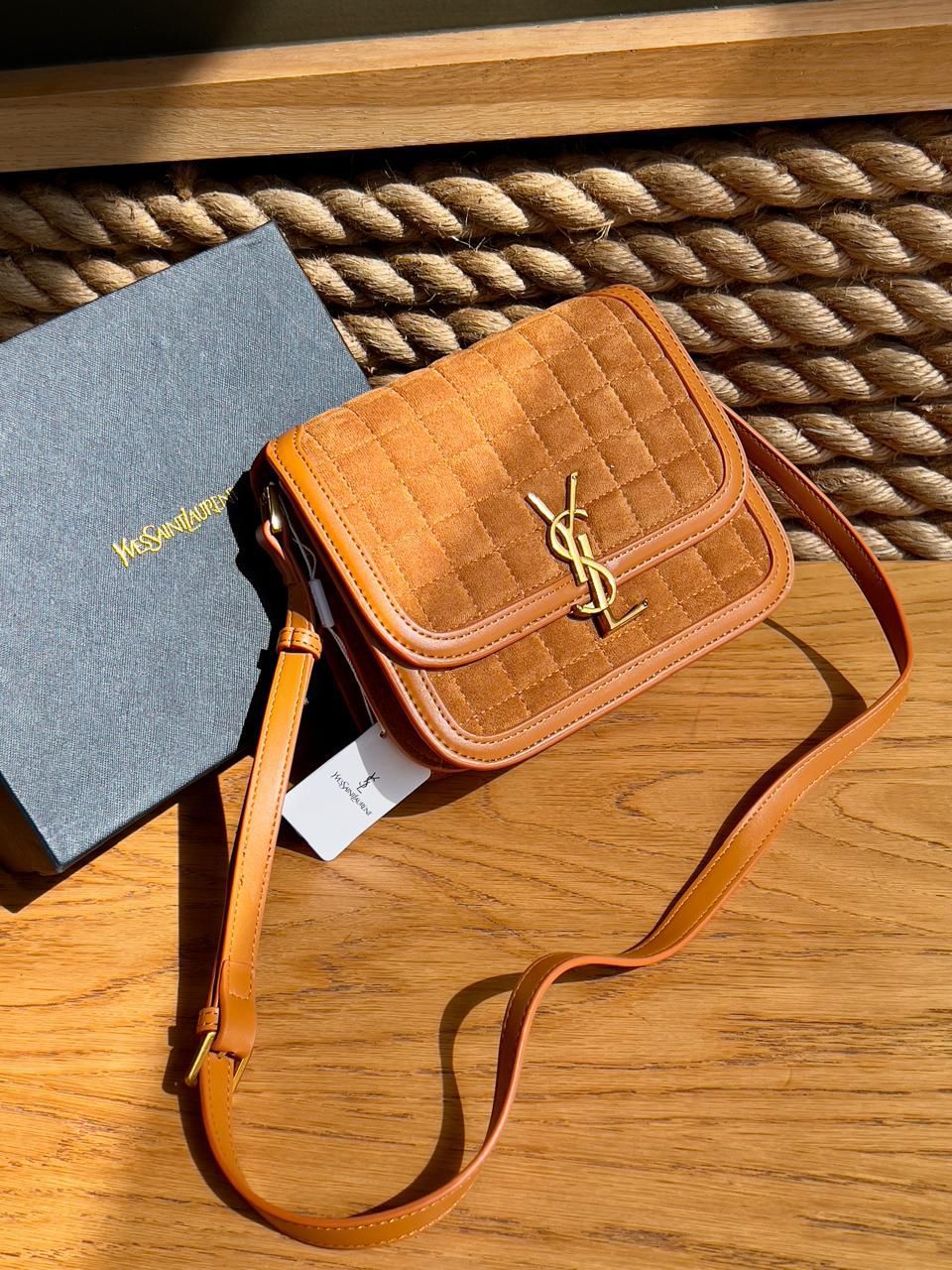 Brown Yves Saint Laurent YSL Premium Shoulder Bag Quilted brown handbag with YSL logo on a wooden surface