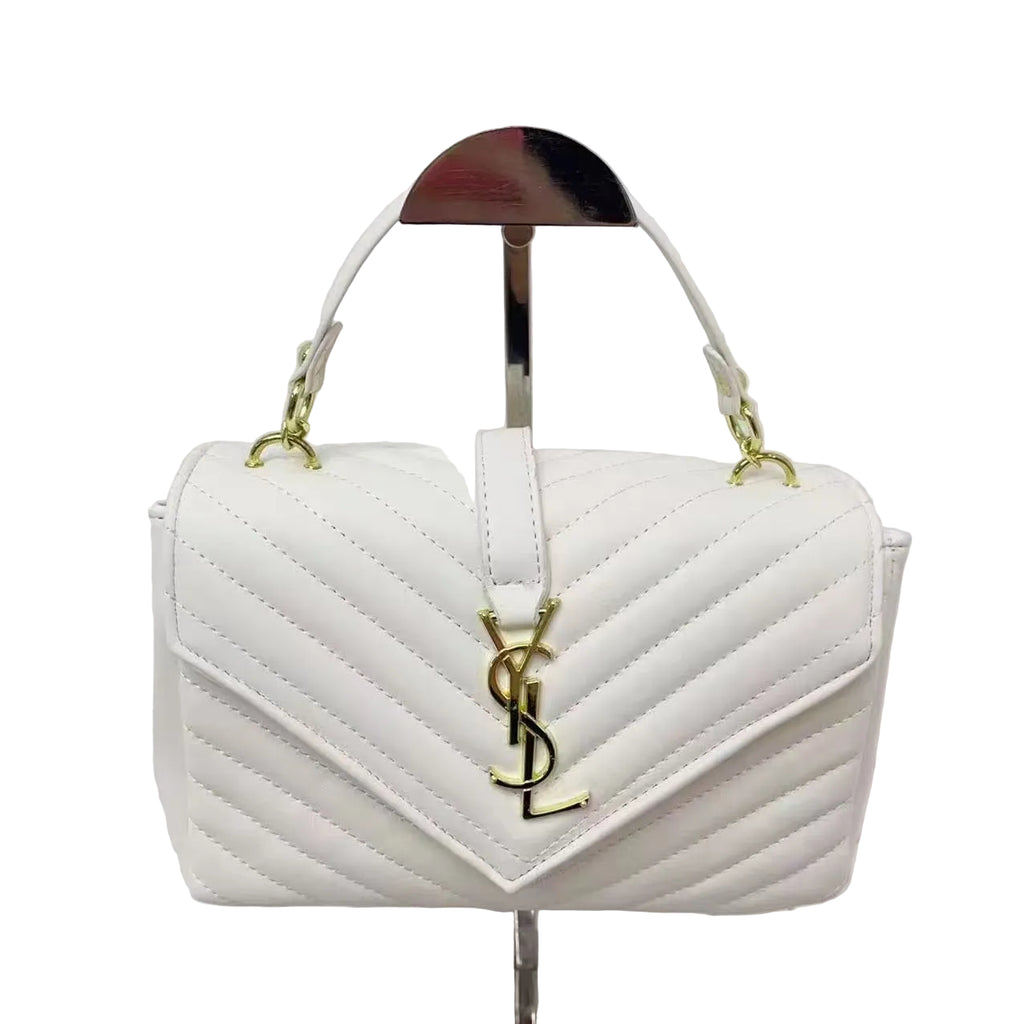 White YSL Saint Laurent Sling Bag quilted handbag with gold accents on a stand against a light gray background