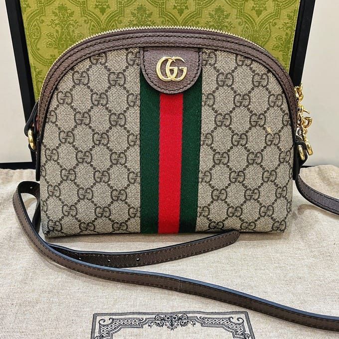 Gucci Ophidia Small Shoulder Bag with monogram pattern and red and green stripes on a neutral background