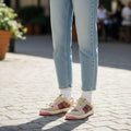 Gucci Women’s Premium Sneakers Person wearing a pink sweater, light blue jeans, and colorful sneakers on a paved outdoor area.