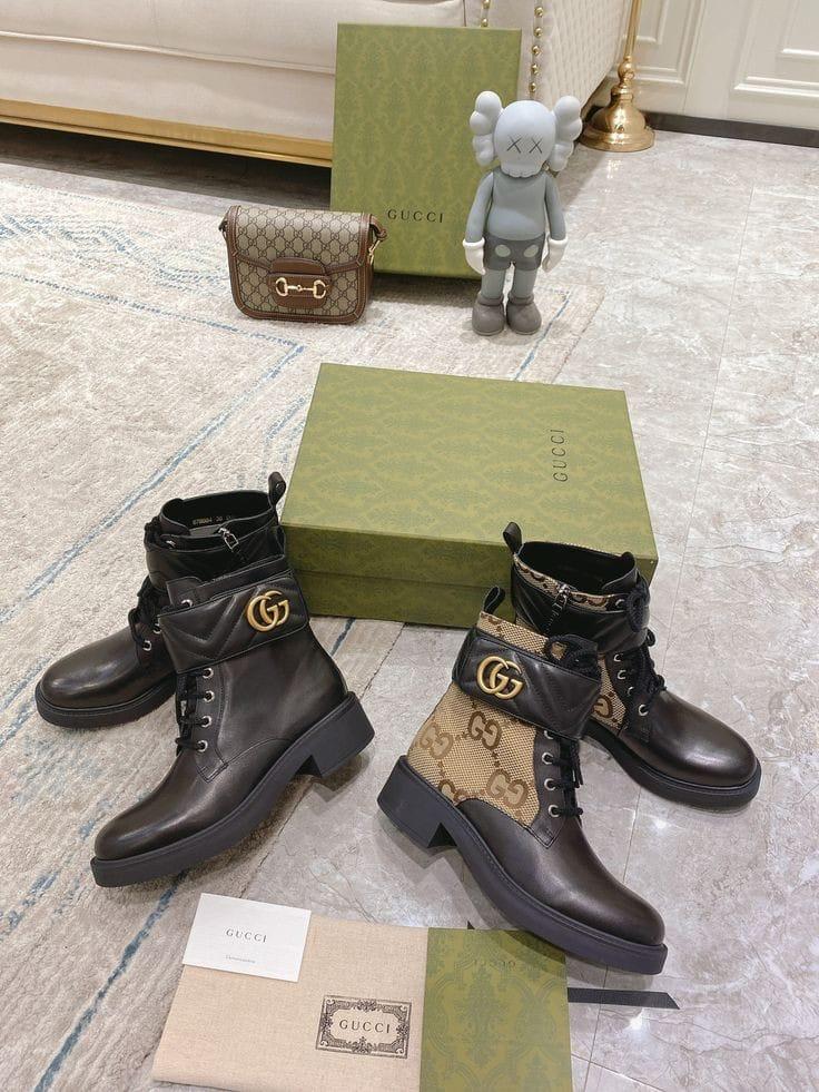 Pair of Gucci boots with a green box and Gucci bag on a patterned floor.
